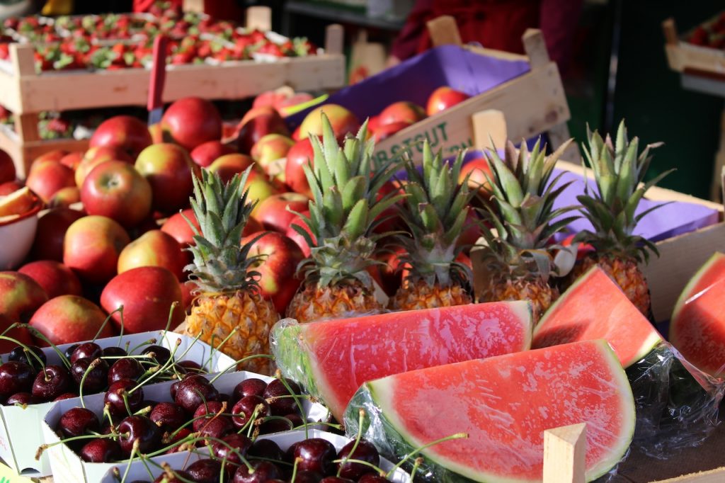 Bild Obstsortiment auf Verkaufsstand mit Wassermelonen, Ananas, Kirschen, Äpfeln und Weitere